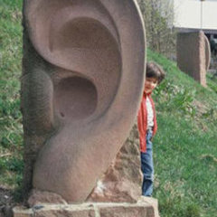 Ohren, Sprech- u. Hörsteine, Zwei Ohrobjekte – von der Hörmuschel aus durchbohrt und miteinander durch ein Rohr verbunden Sandstein, 1998 Bad Bellingen, Kurpark